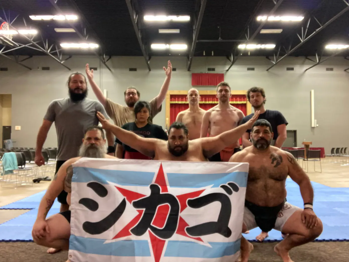 Wrestlers holding a Chicago flag banner in a gymnasium
