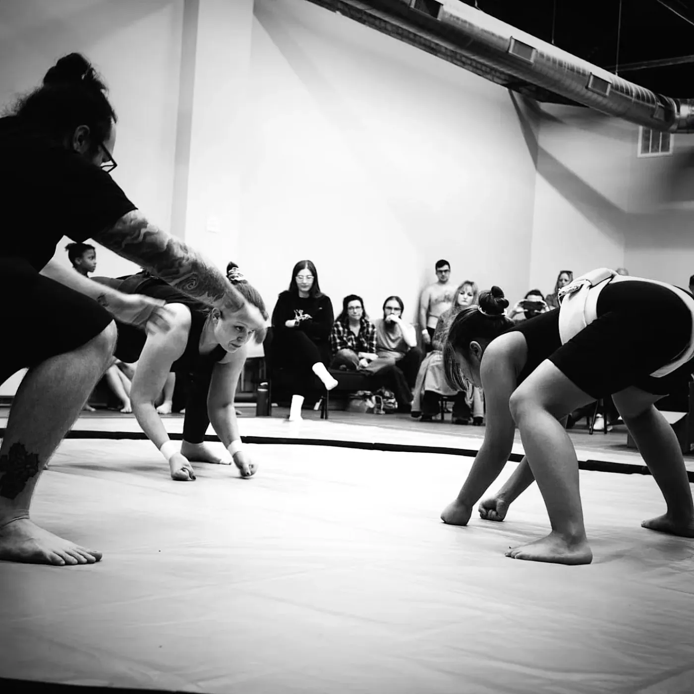 Two wrestlers crouched and facing each other before the charge